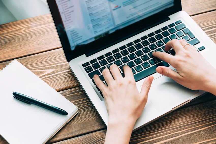 A person Sitting At a Desk Typing On a Keyboard