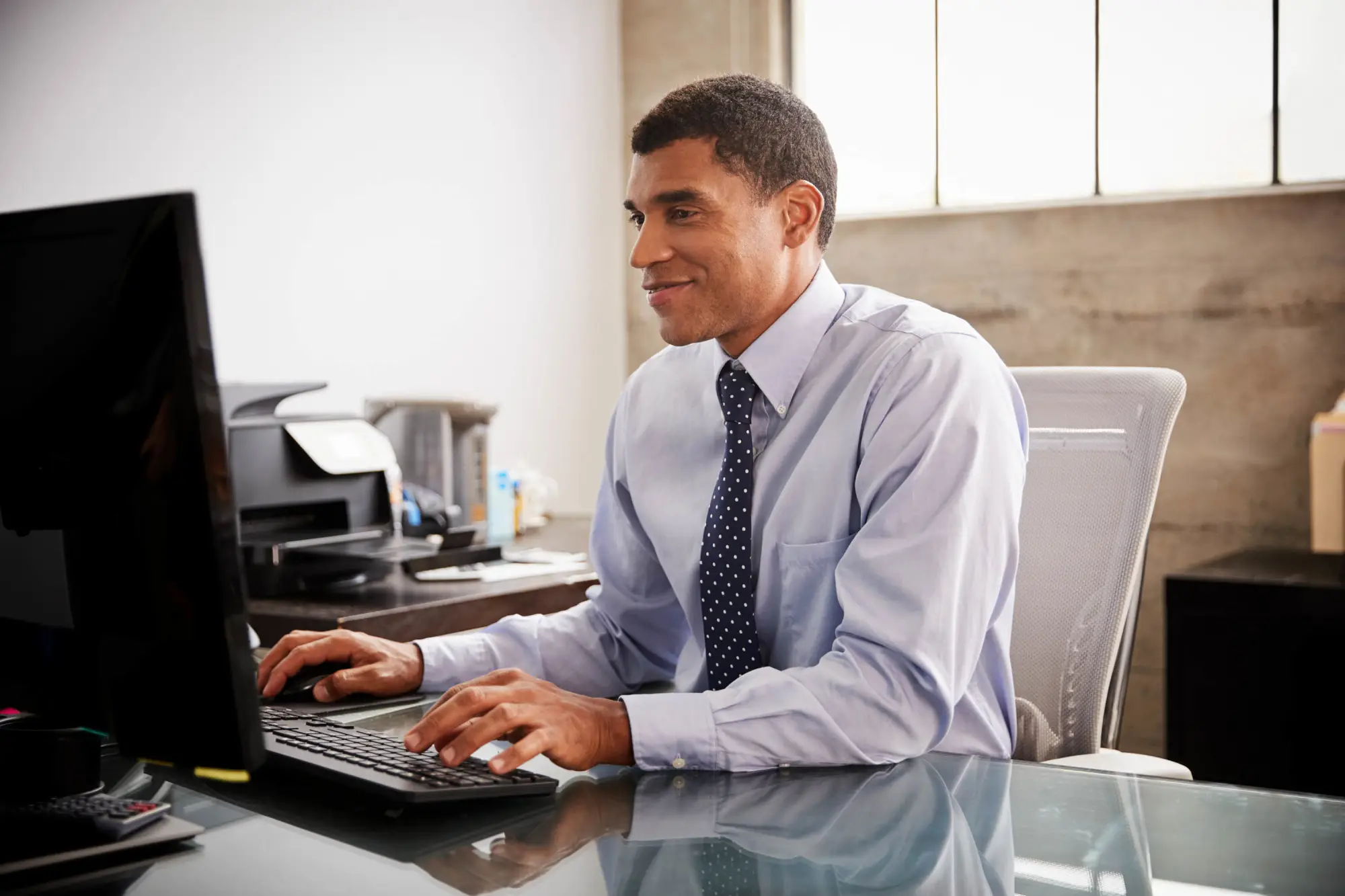 young business man in office on desktop computer