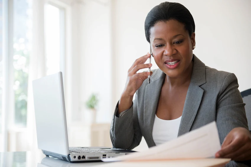 business woman on chatting on cellphone with laptop