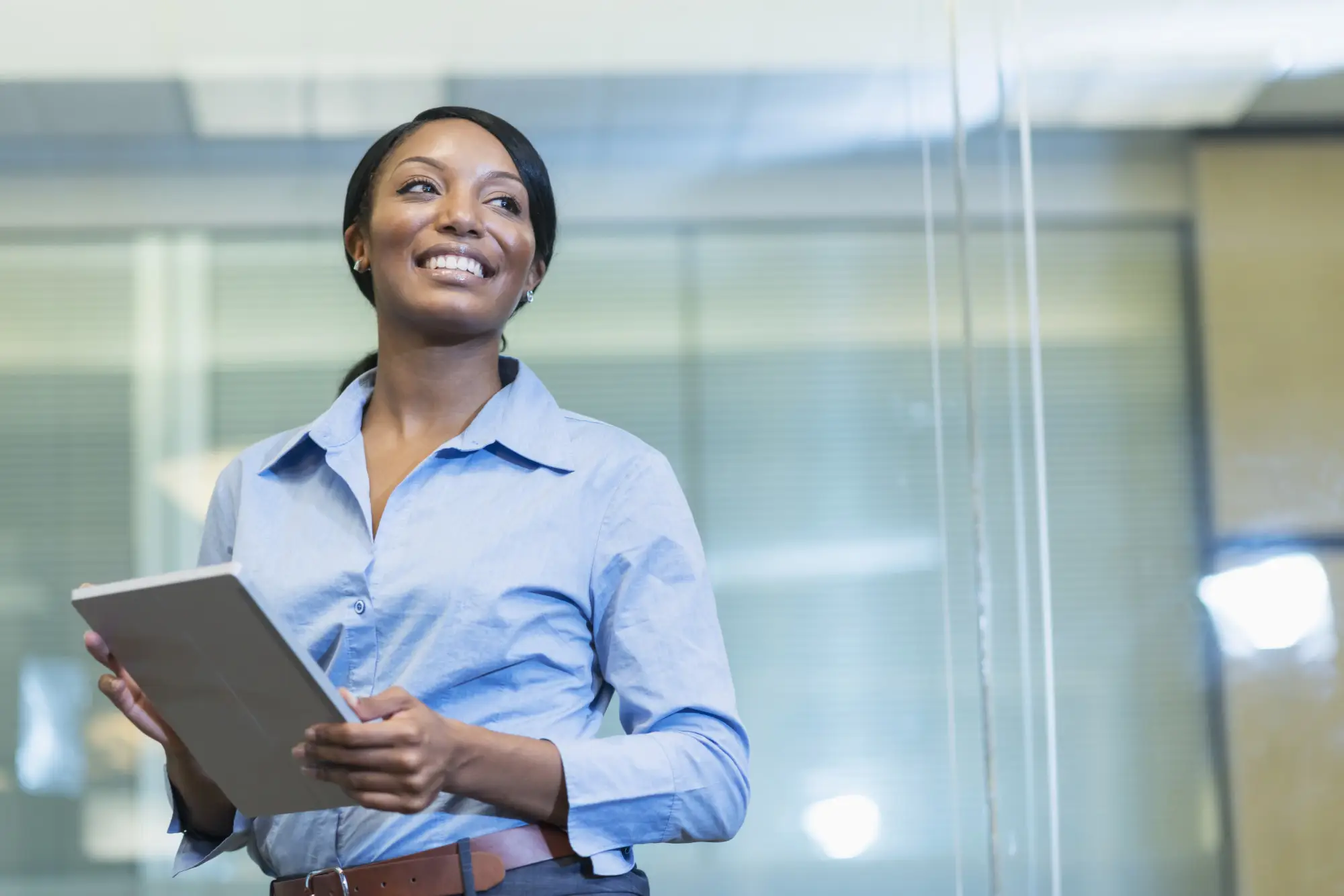 smiling woman holding a table in an office environment