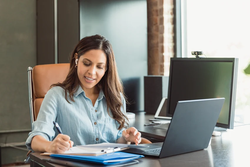 Woman Writing Something Down With Laptop