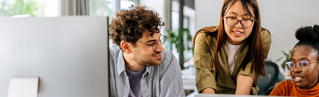 Students collaborating in front of desktop computer