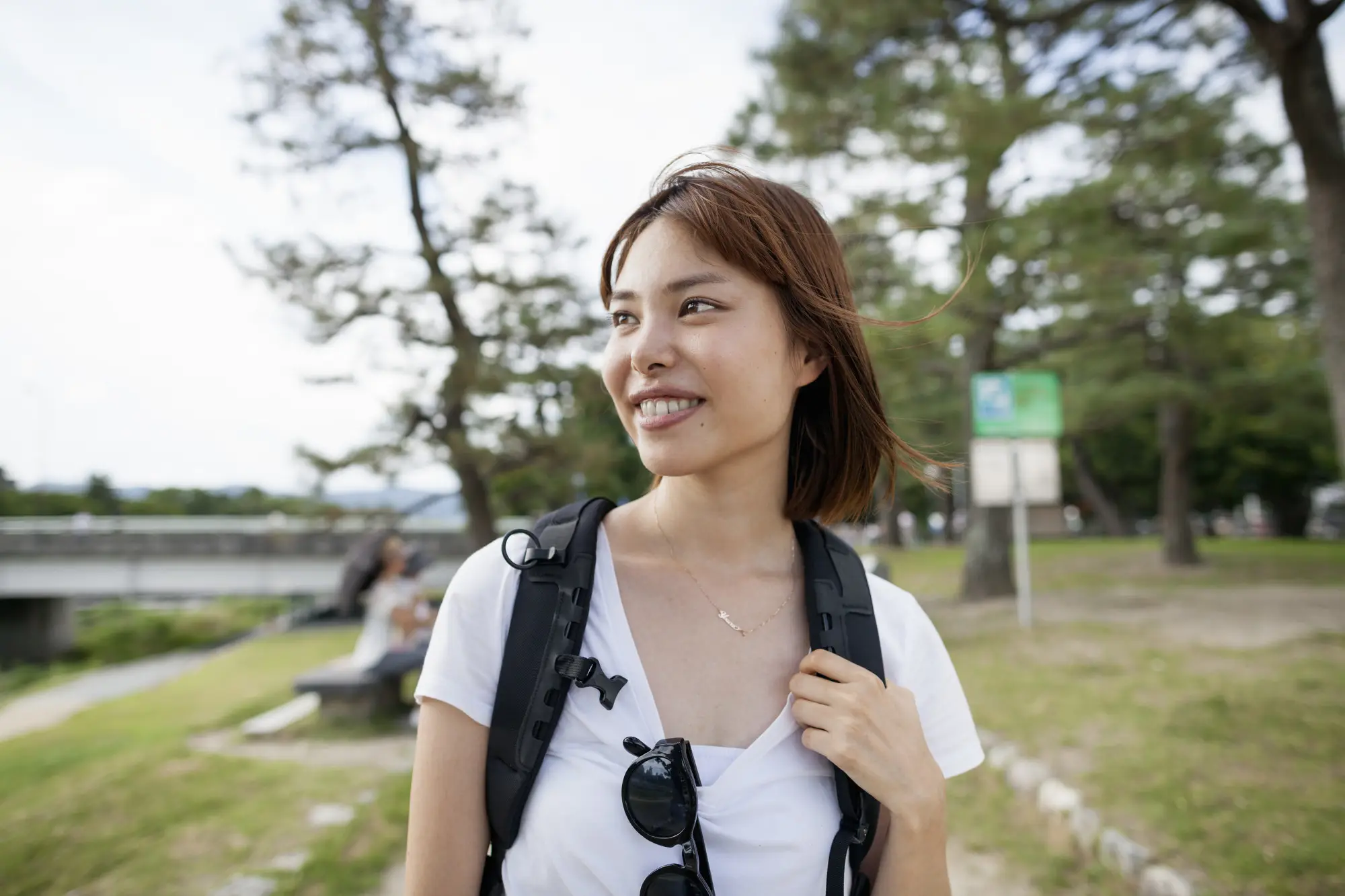 微笑的女人背着背包在户外