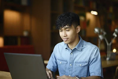 Young male student studying with his computer