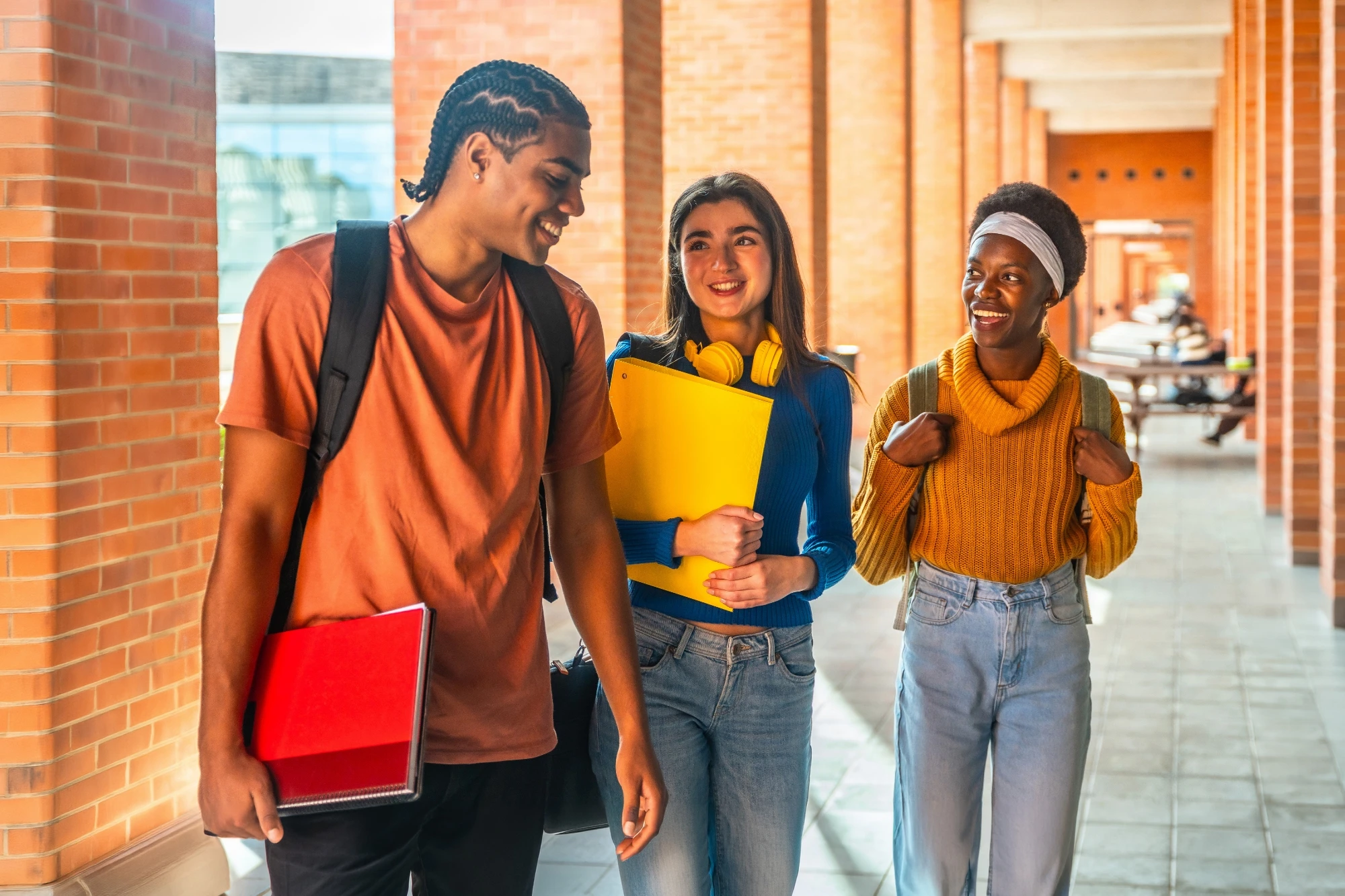 Student friends walking together down a college's outdoor corridor