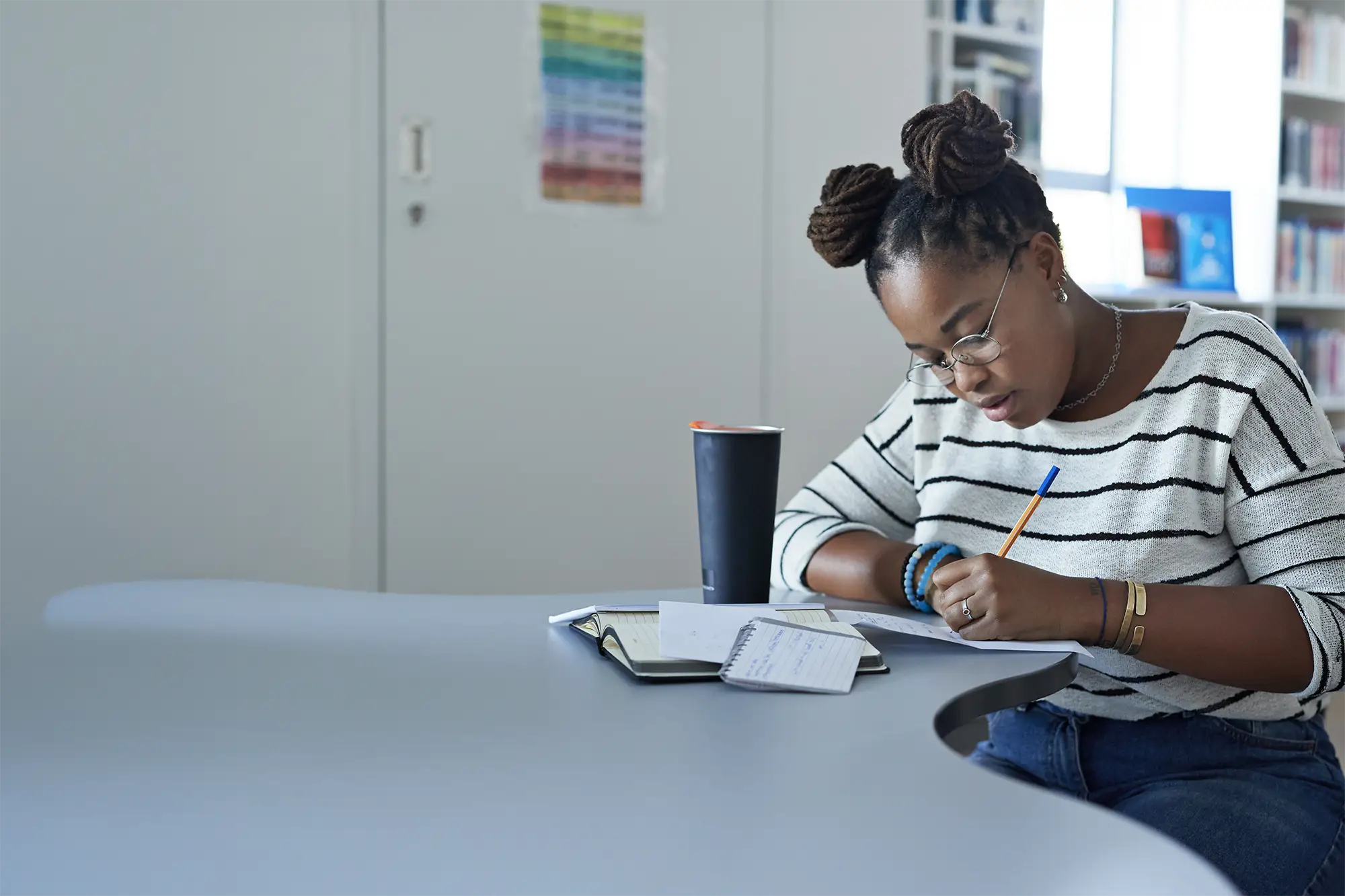Student writing notes at table