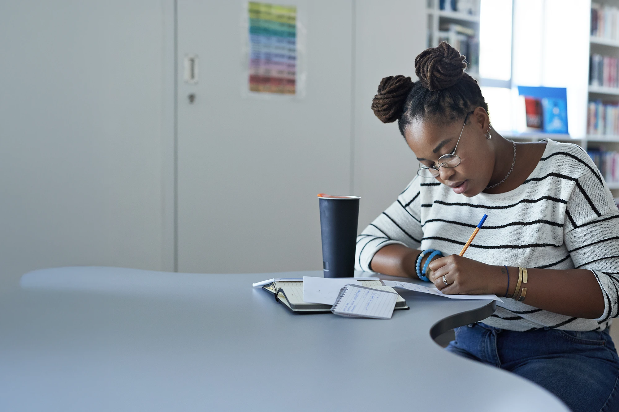 Student writing notes at table