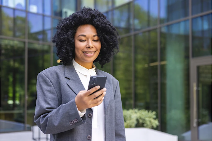 Real Estate Instructor Standing Outdoors Holding a Cellphone