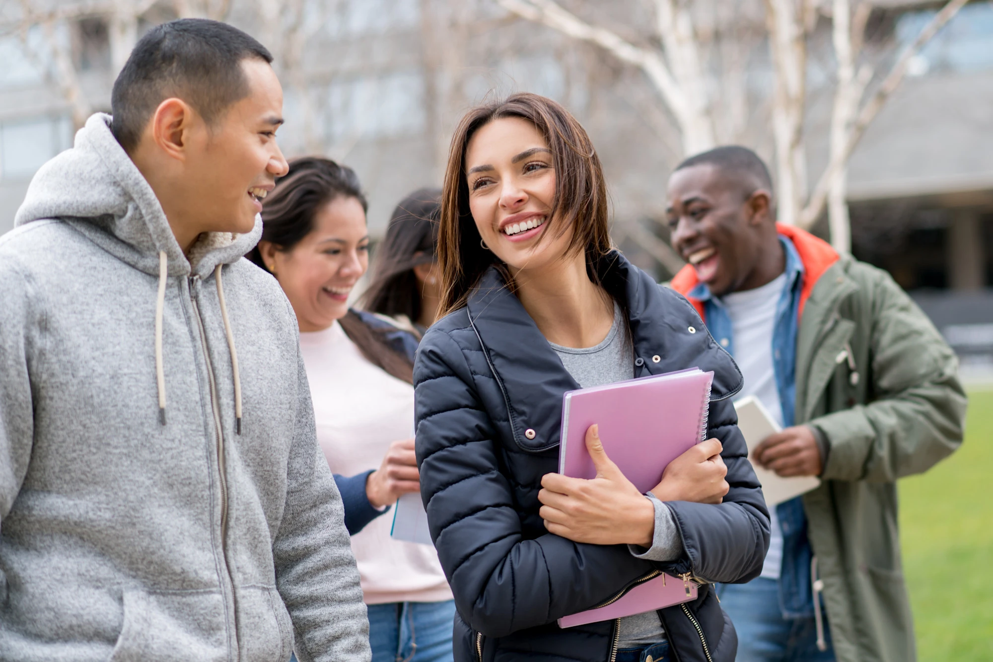 Students smiling, walking, and talking outdoors on campus