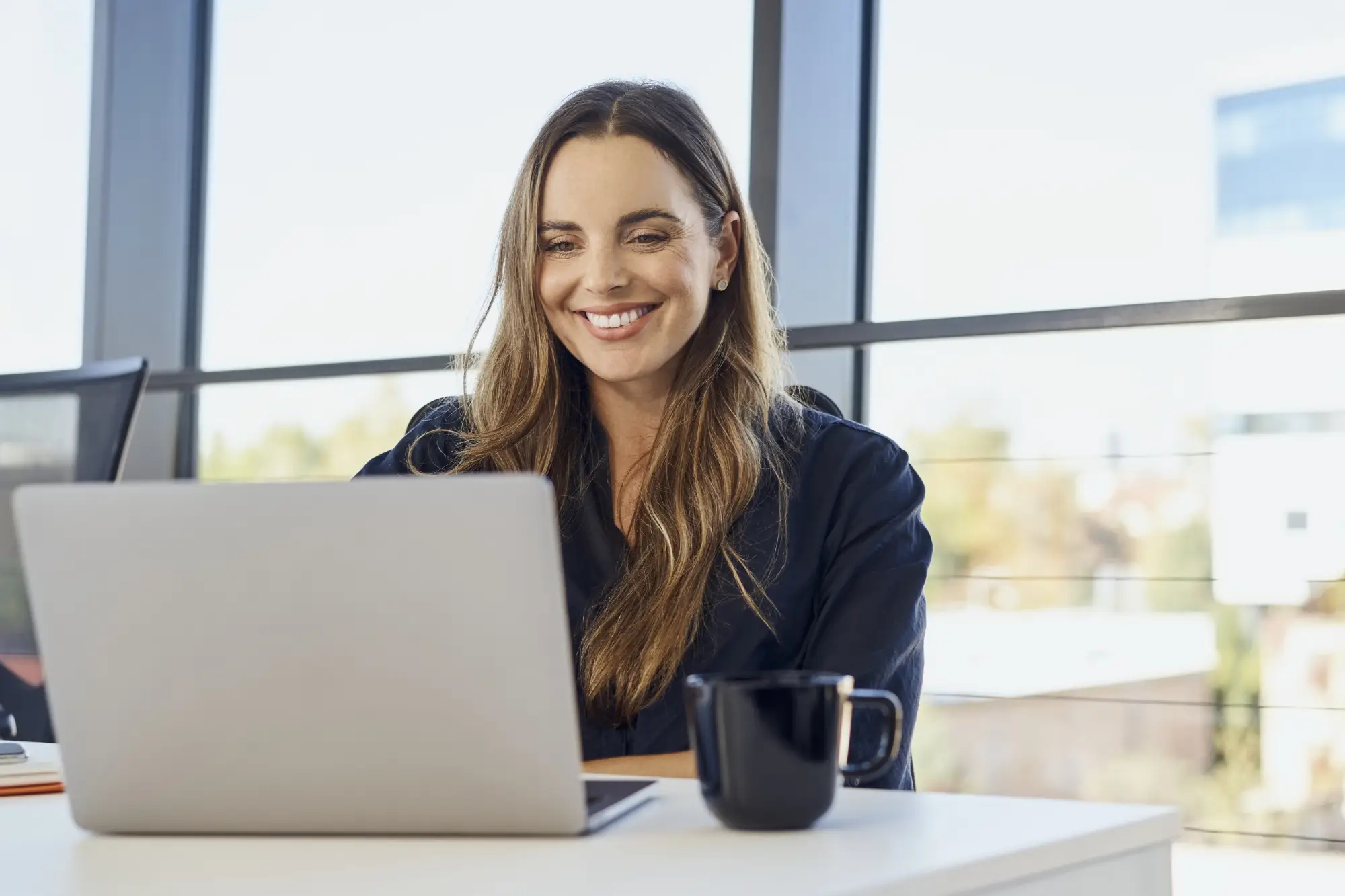 smiling woman on laptop in office setting