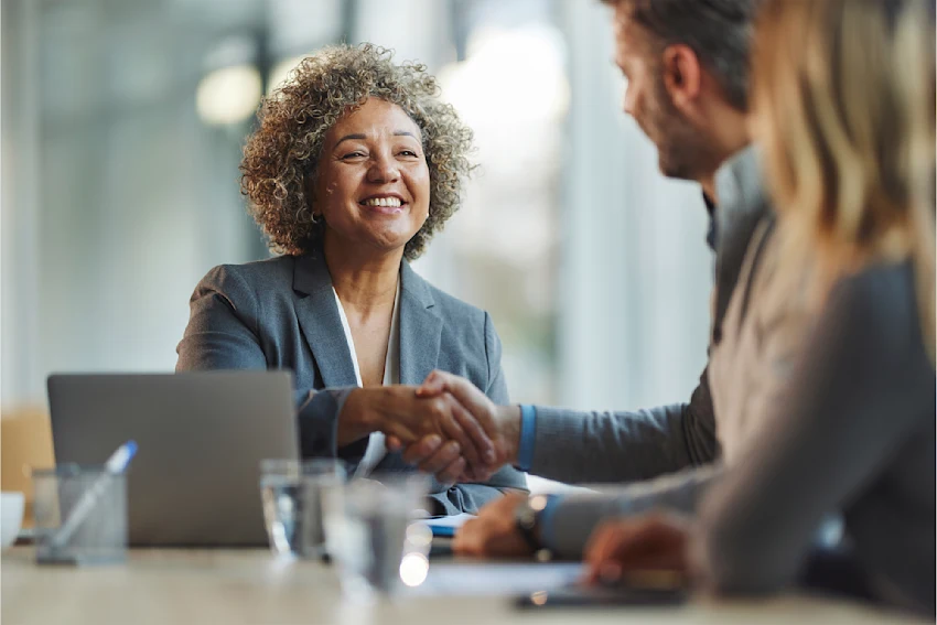dearborn - woman shaking man hand at meeting