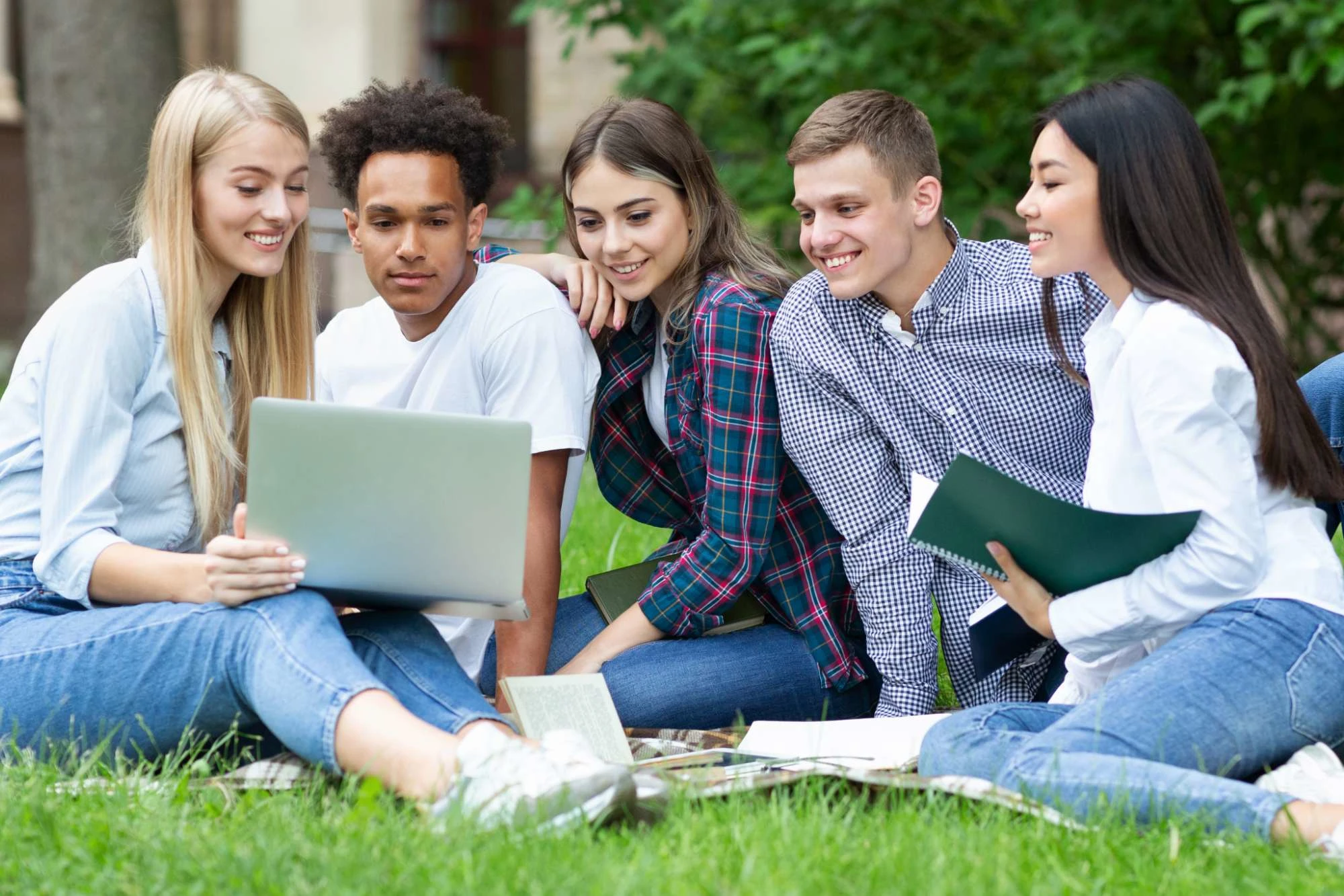 smiling college student leaning against column outdoors on school campus