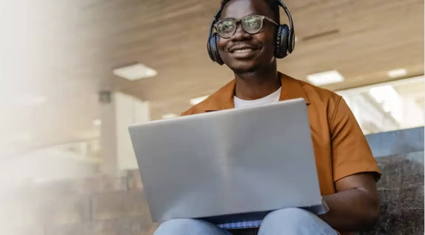 Student sitting with laptop and headphones