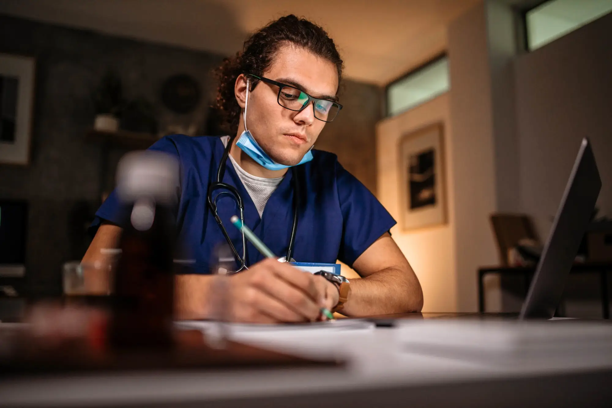 medical professional man with glasses writing something down