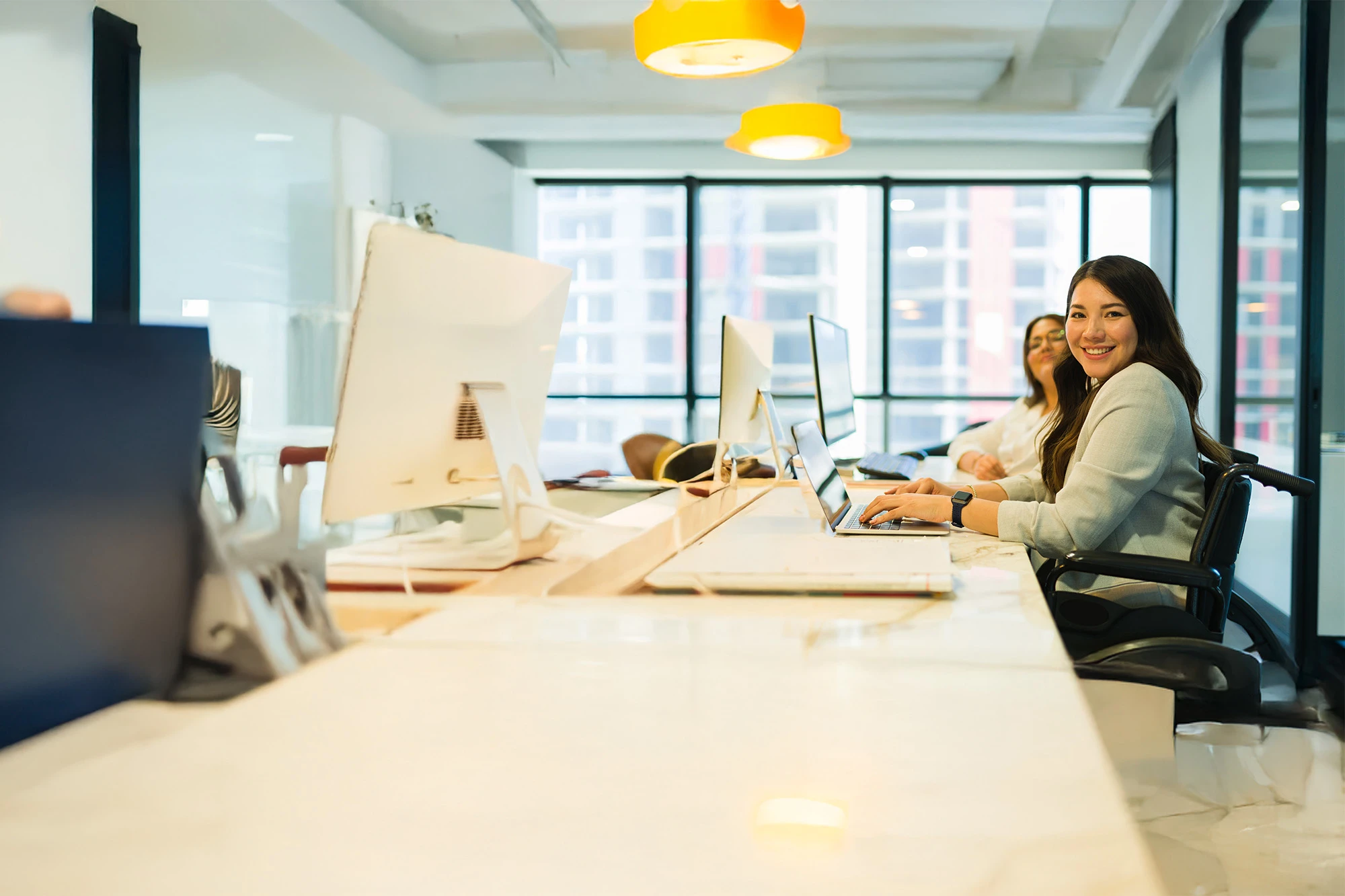 Smiling Gen Z colleagues in modern group work space