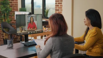 Two coworkers sitting in front of a computer