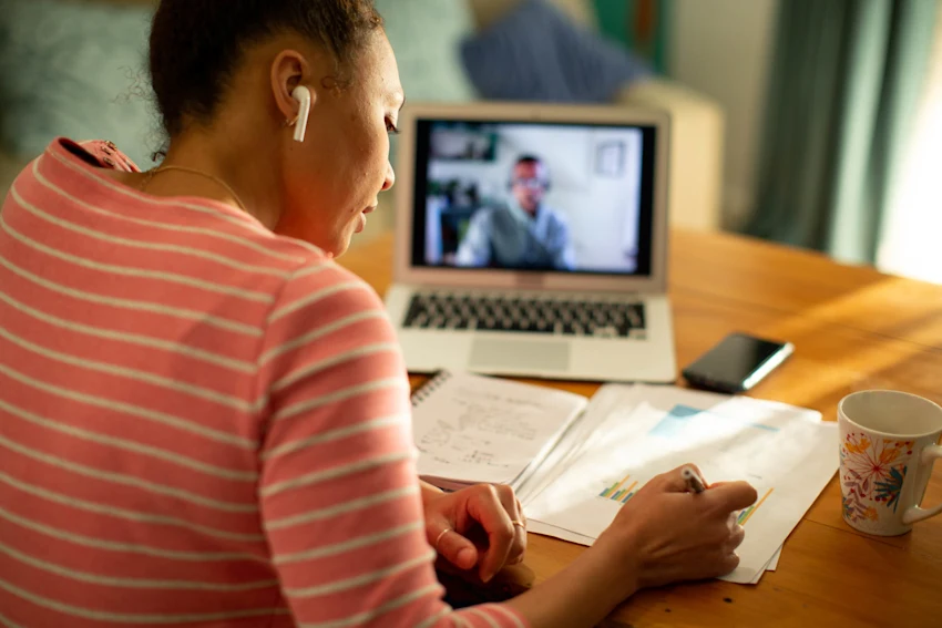 woman in virtual meeting taking notes