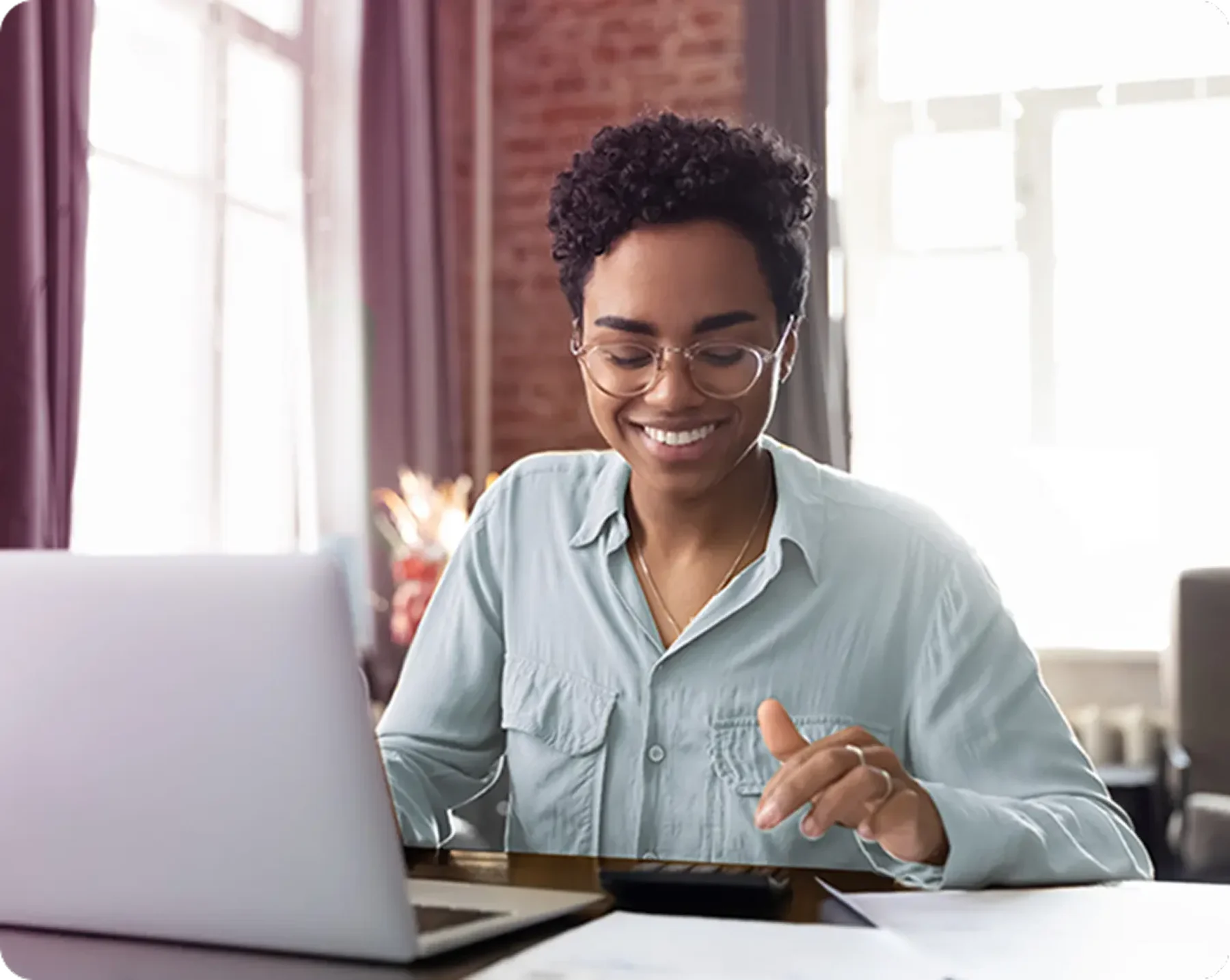 smiling woman at computer looking at benefit accounts