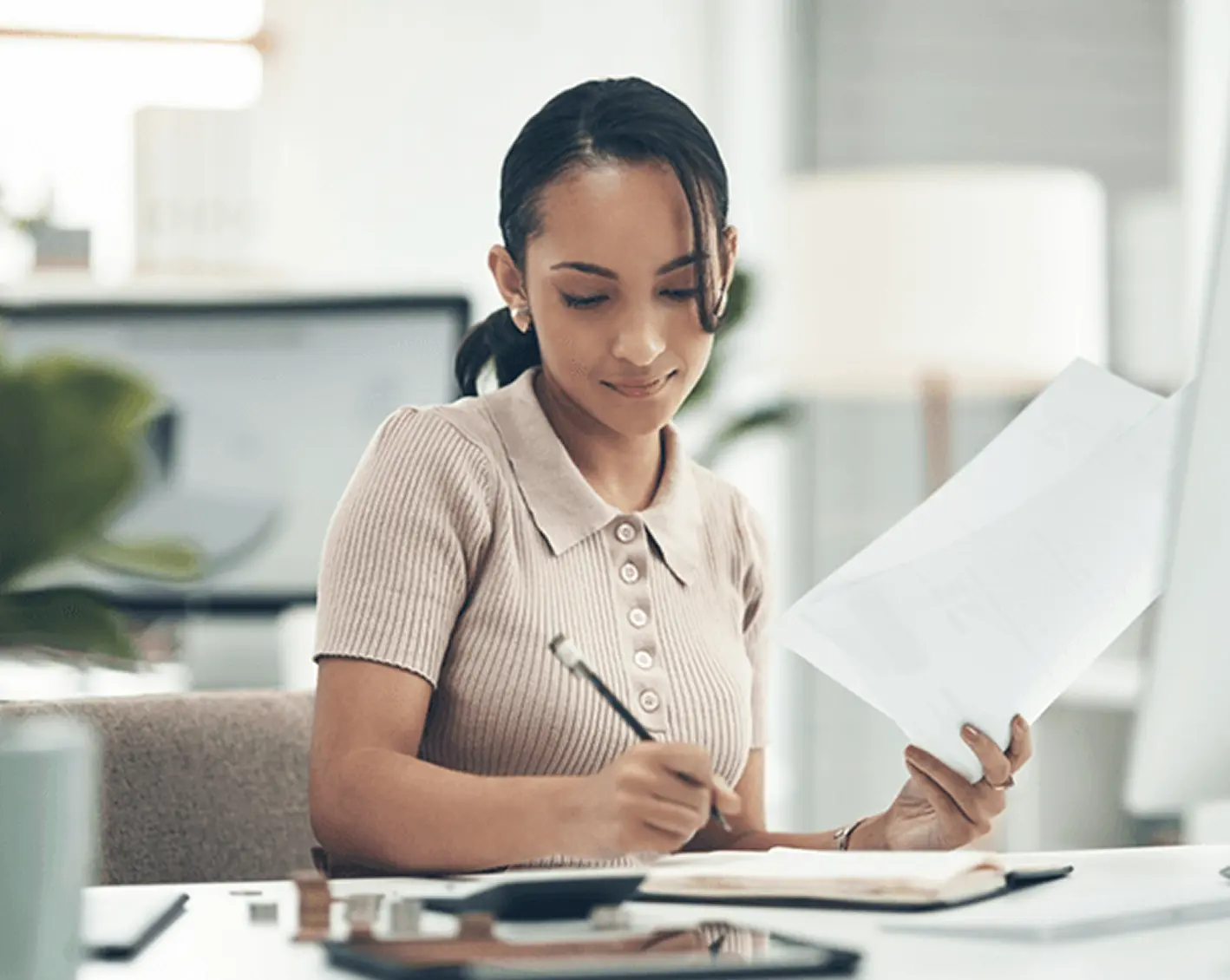 hr admin using payroll software and taking notes