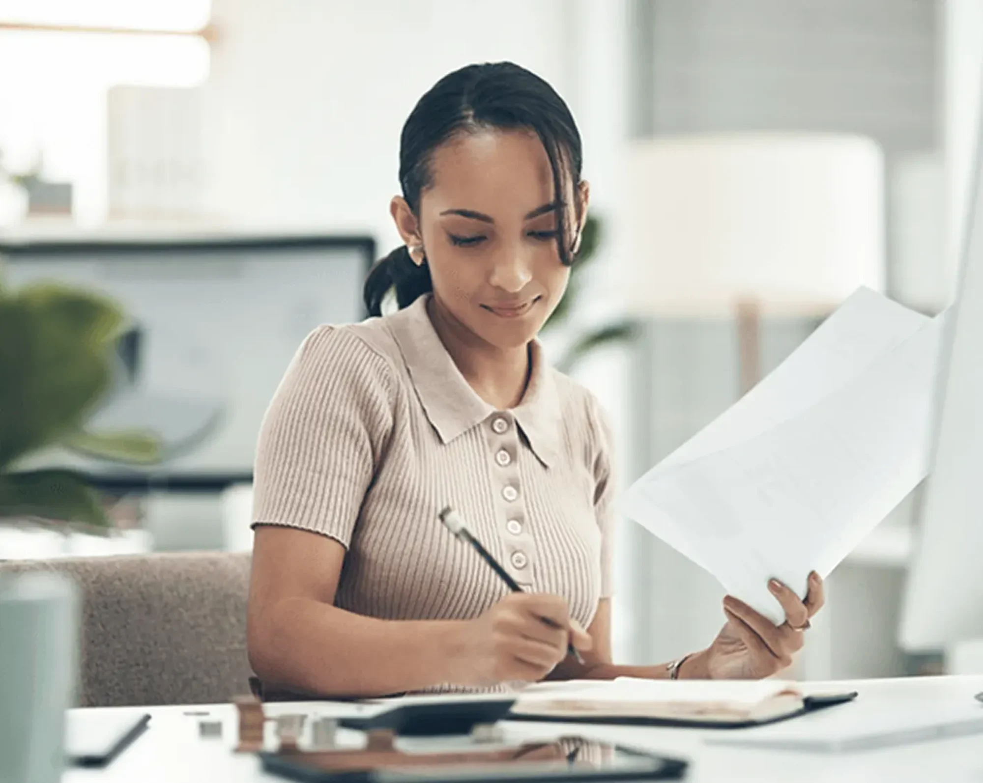 hr admin using payroll software and taking notes