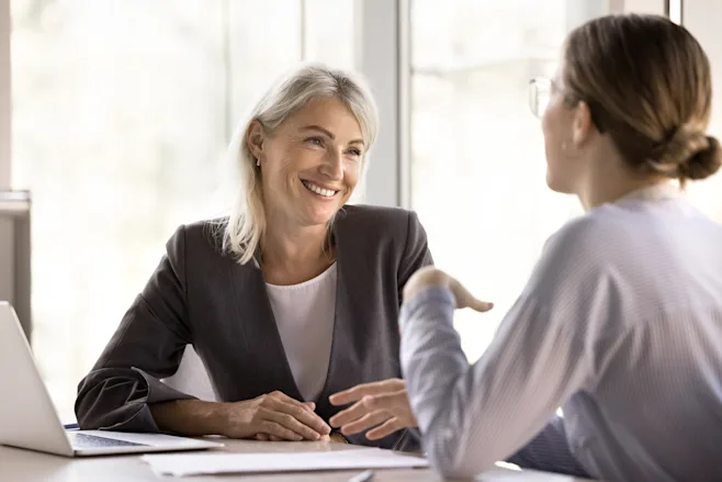 Two women talking at a desk