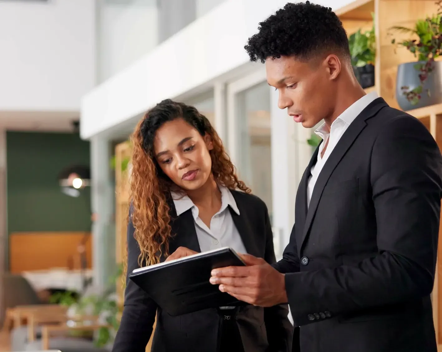a couple of hotel employees making notes on tablet