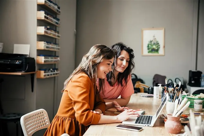 Two women looking at a laptop