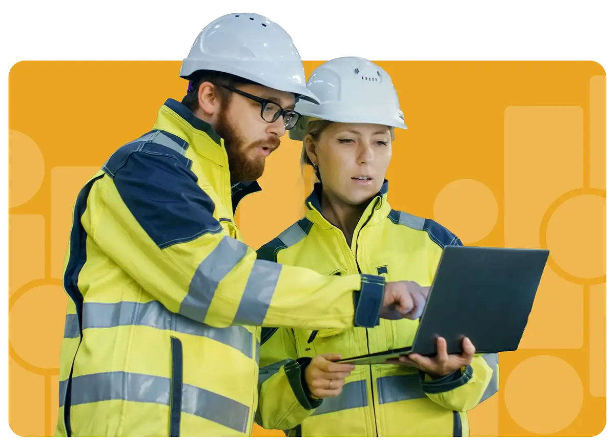 construction workers looking over engineering plans on laptop