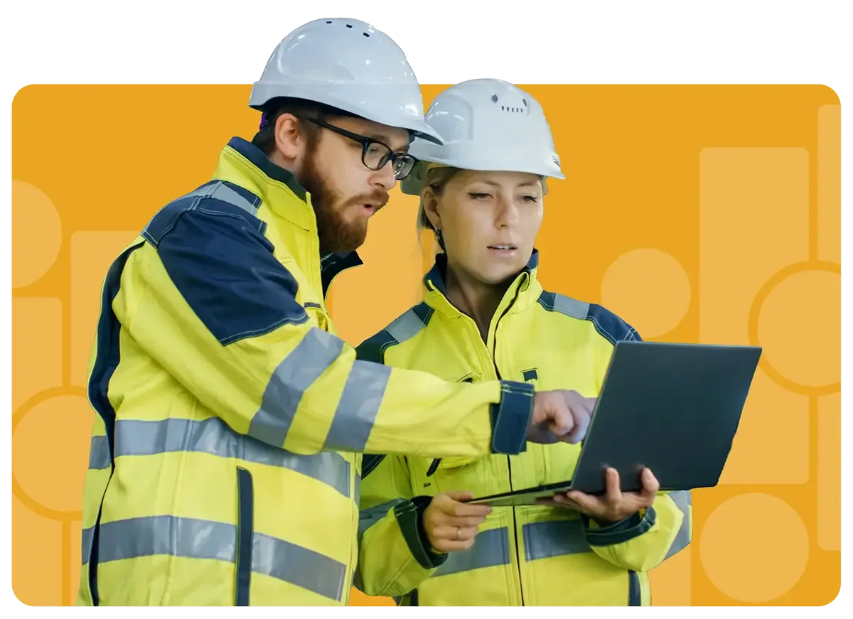 construction workers looking over engineering plans on laptop
