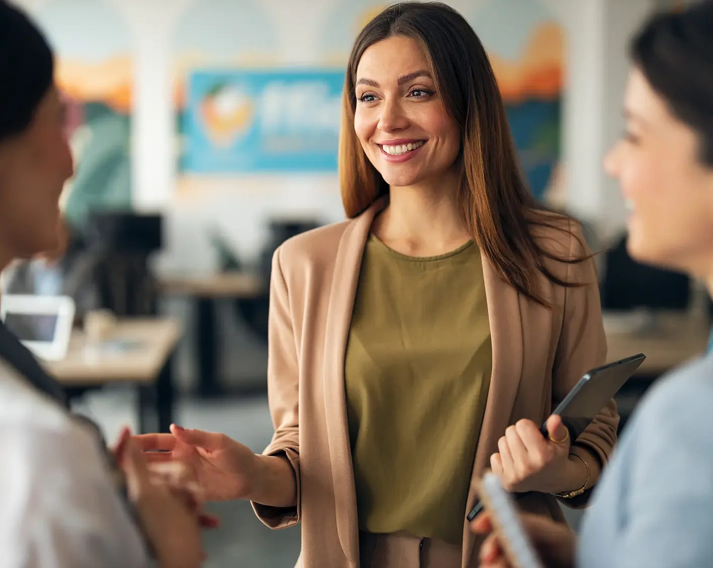 smiling woman talking with coworkers