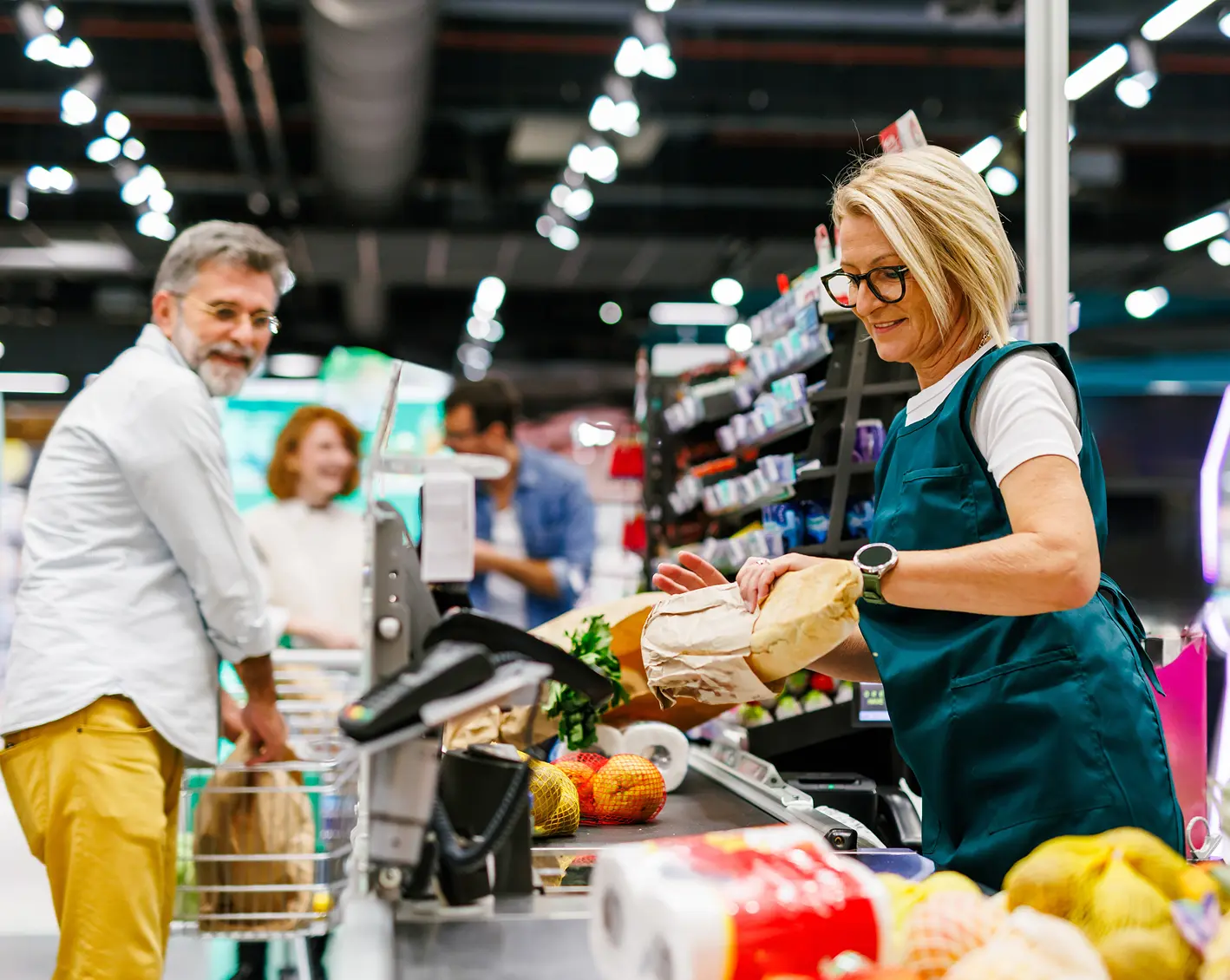 woman cashier helping man purchase his groceries