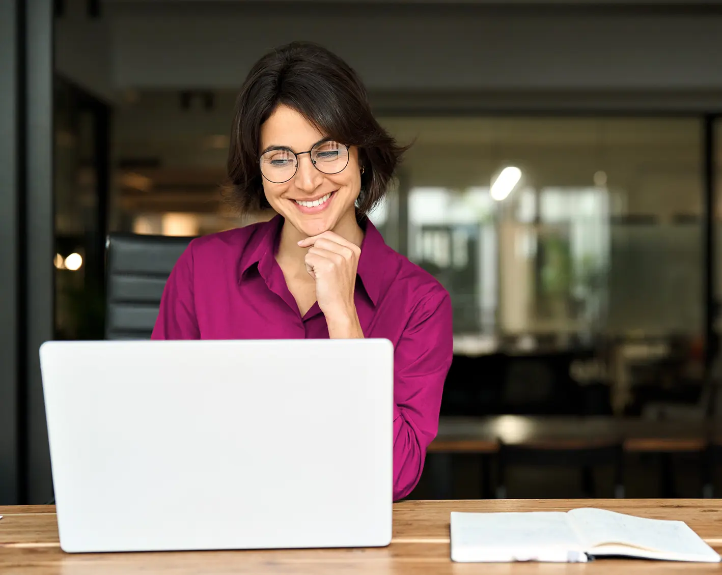 woman smiling at managing employees on computer