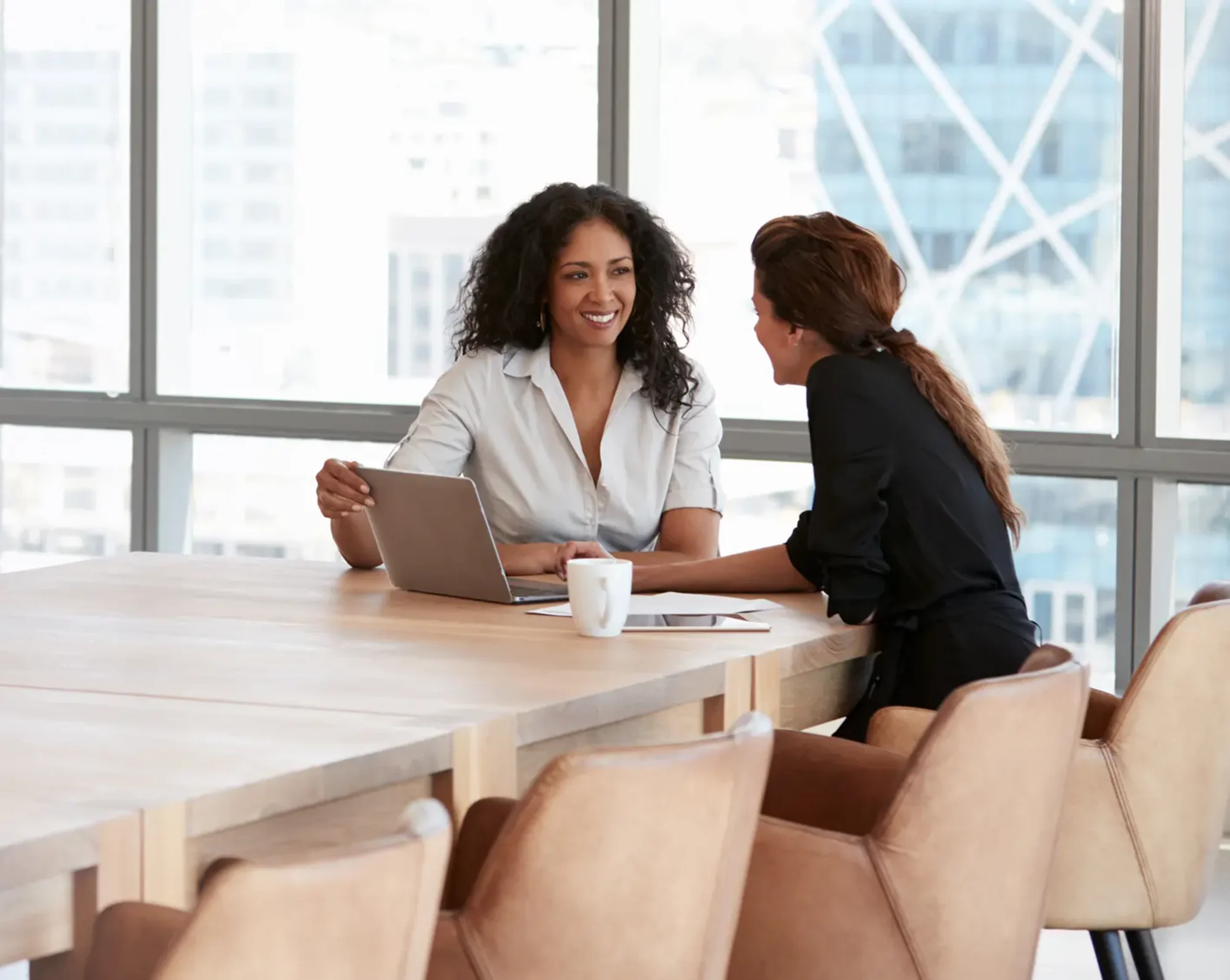 2 business women at large conference table