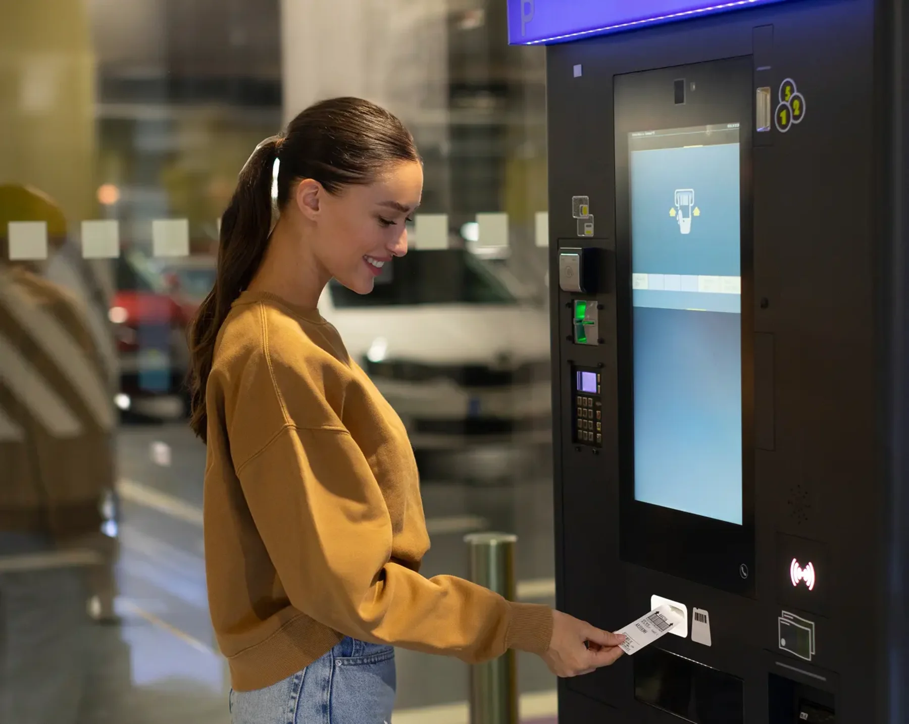 woman using transit parking benefits at machine