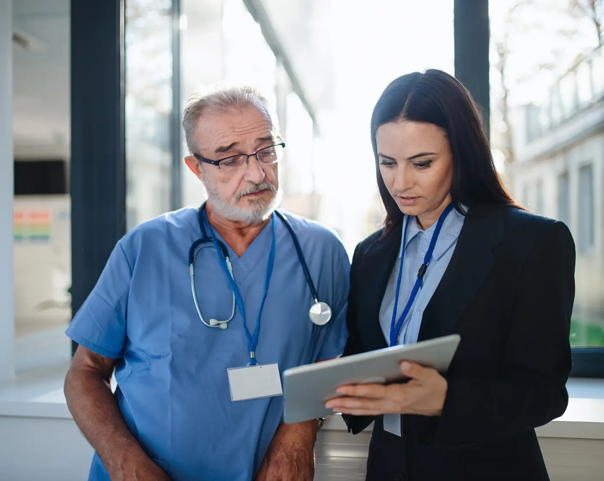 healthcare workers looking at patient charts on tablet