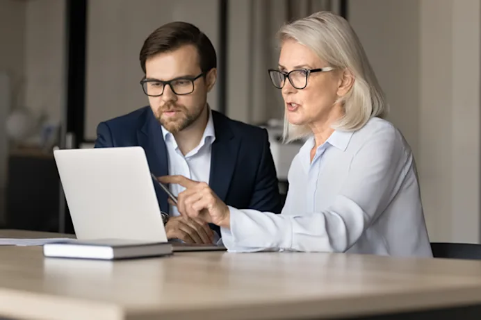 Two people looking at a screen during a meeting 