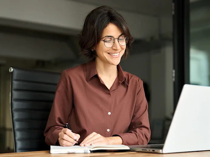 Video play icon. Smiling woman sitting at a laptop