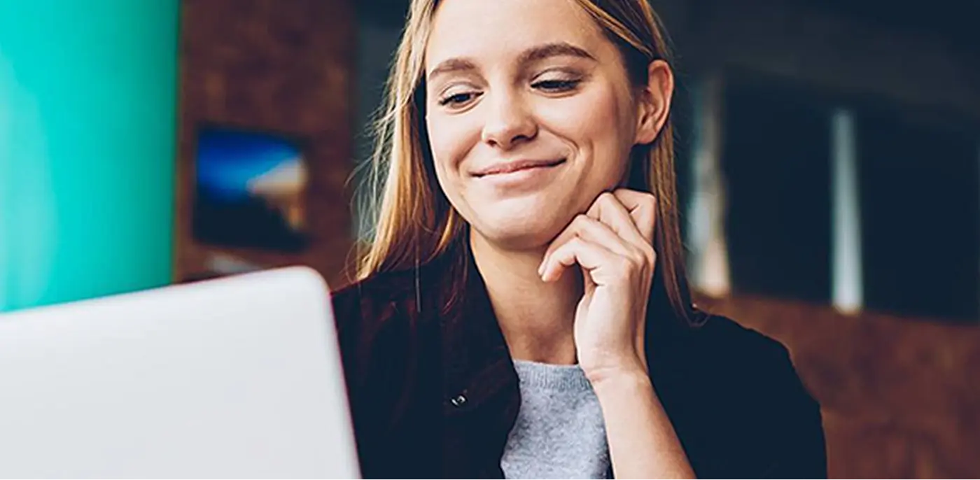 smiling woman looking at benefits on computer