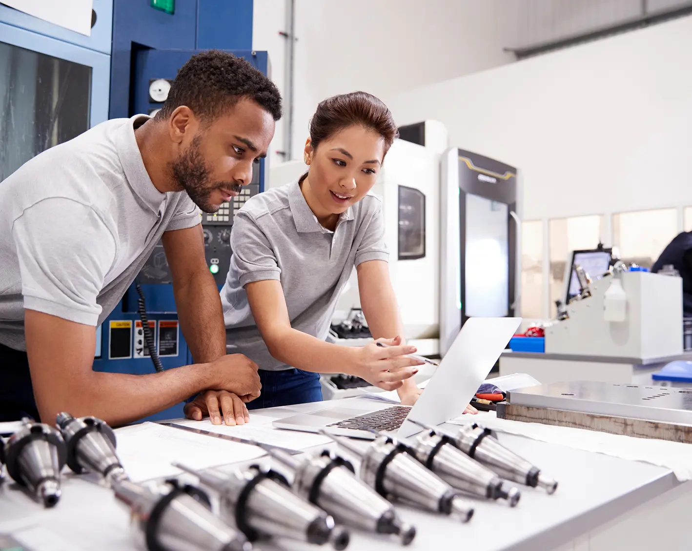 a couple of manufacturing workers looking over instructions