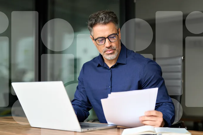 Man in blue shirt looking at paperwork