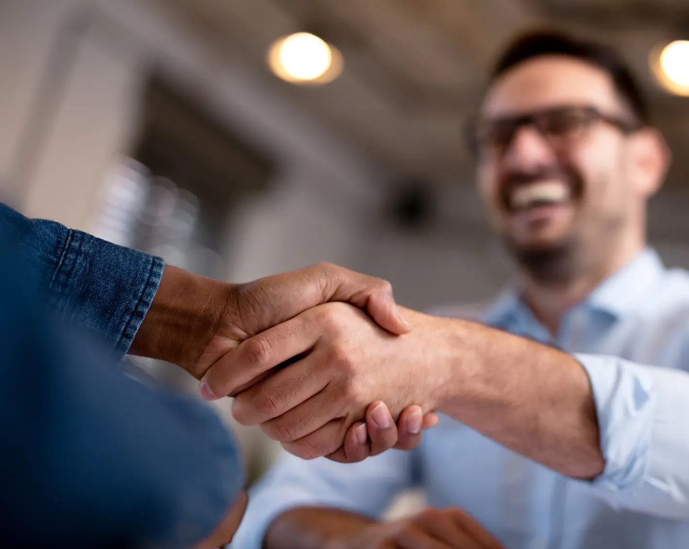 two businessmen shaking hands and smiling