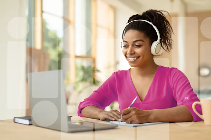 Woman writing in front of a laptop