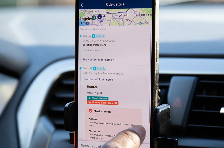 CareDriver app on a phone in a car mount showing ride details with pickup, drop-off, and rider notes for Hunter