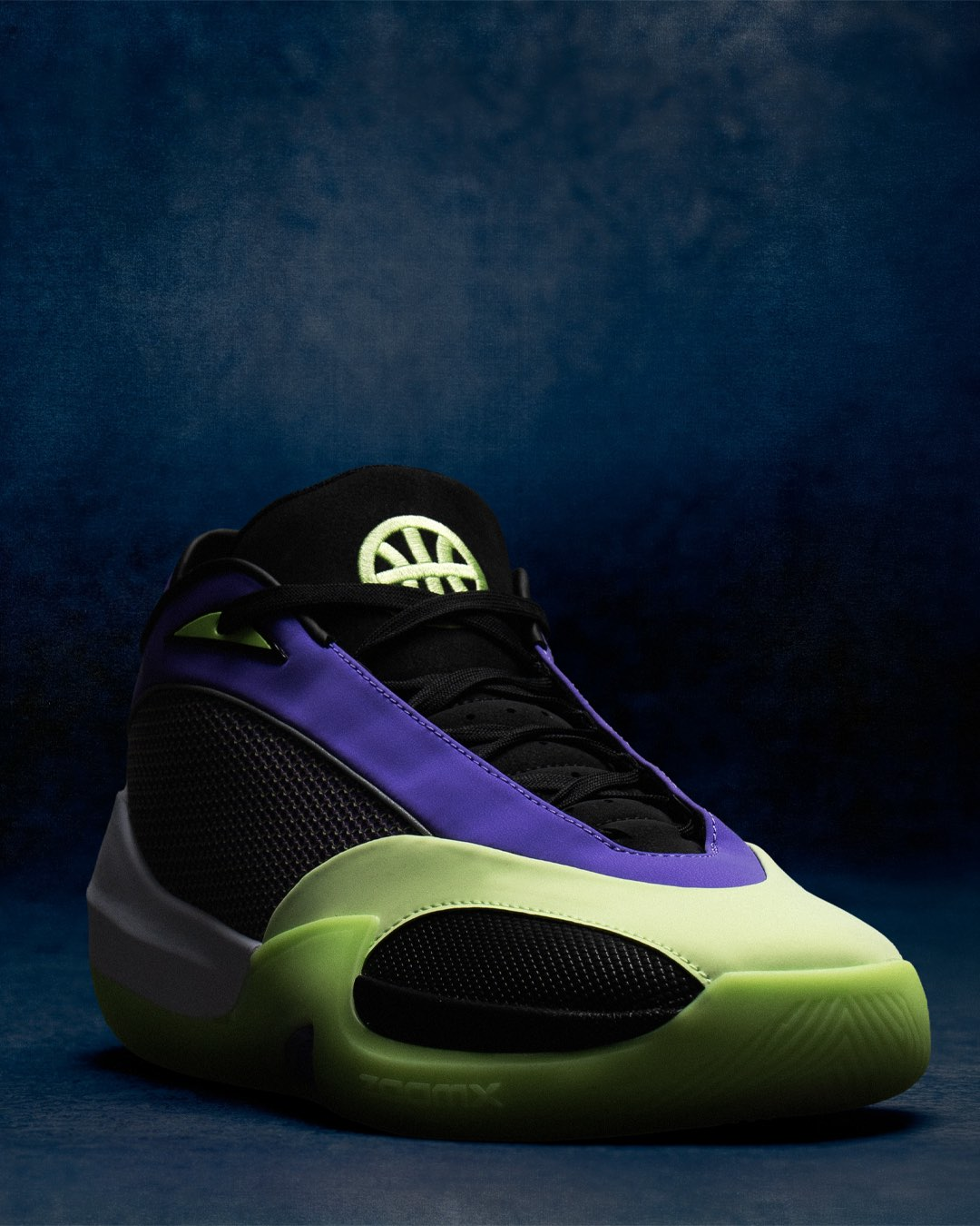 Close-up lateral profile of a single Jordan Triangle Q54 basketball shoe against a dark blue background. The black mesh upper features a smooth deep purple overlay running along the midfoot and collar, with volt green accents on the lace loops. A volt green embroidered Quai54 basketball logo sits on the black tongue. The oversized volt green midsole wraps the forefoot with a sculpted cutout window exposing the black lower sidewall. Subtle text branding is visible on the midsole edge.
