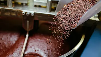 Scoop pouring chocolate in mixing bowl