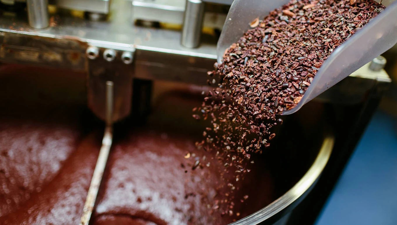 Scoop pouring chocolate in mixing bowl