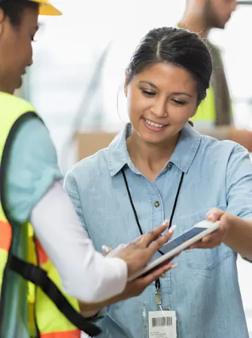 Woman handing over tablet to sign.