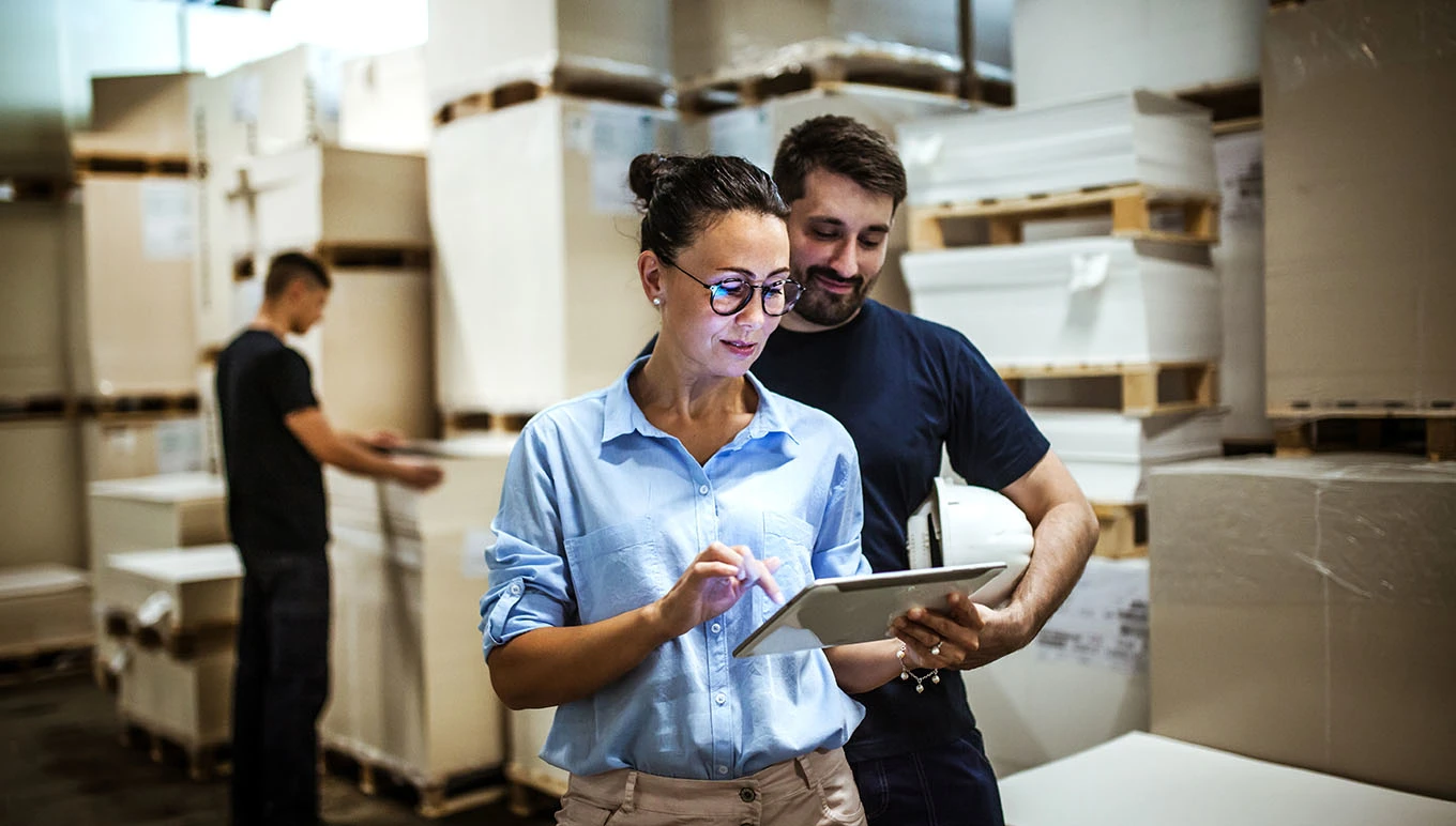 woman and man in warehouse on tablet