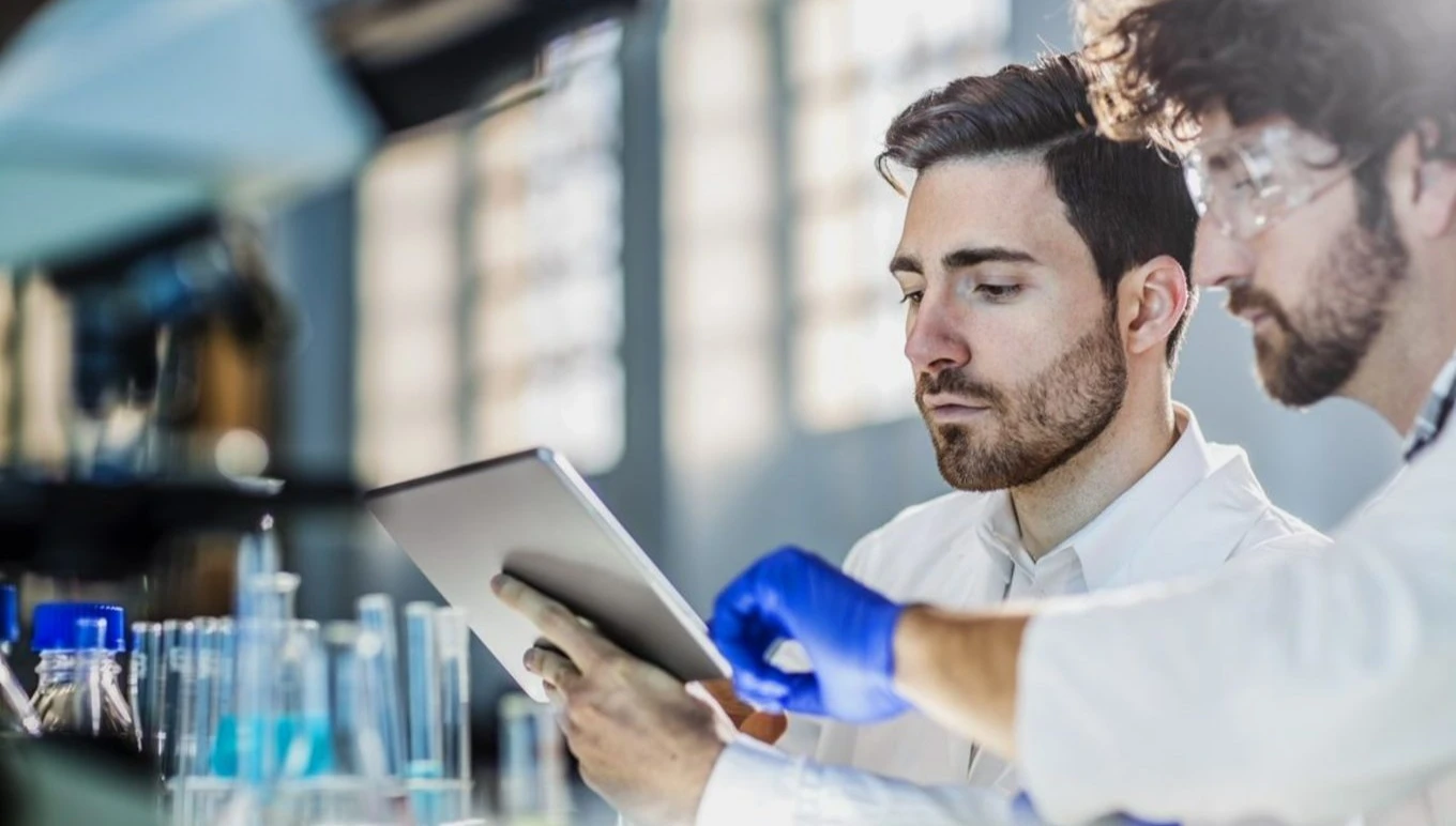 Two scientists looking at a tablet.