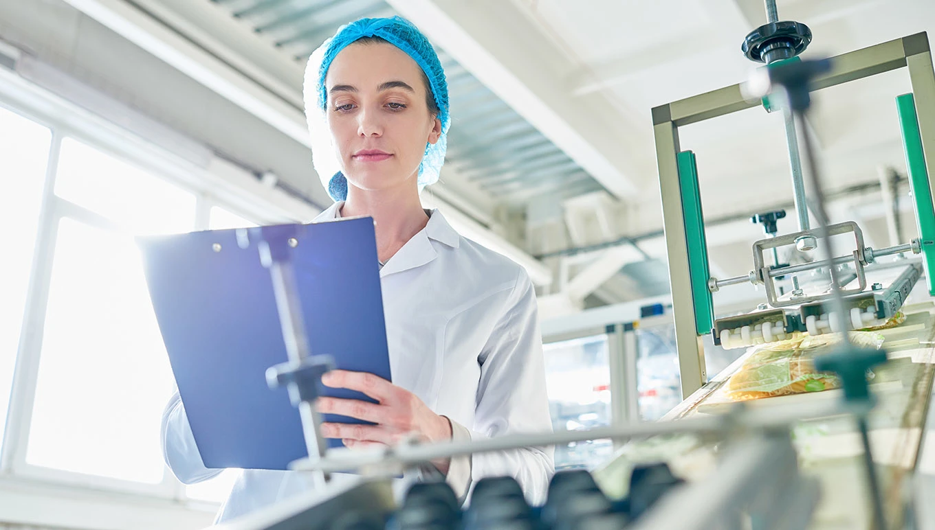 A food facility worker reviews records associated with a product line.